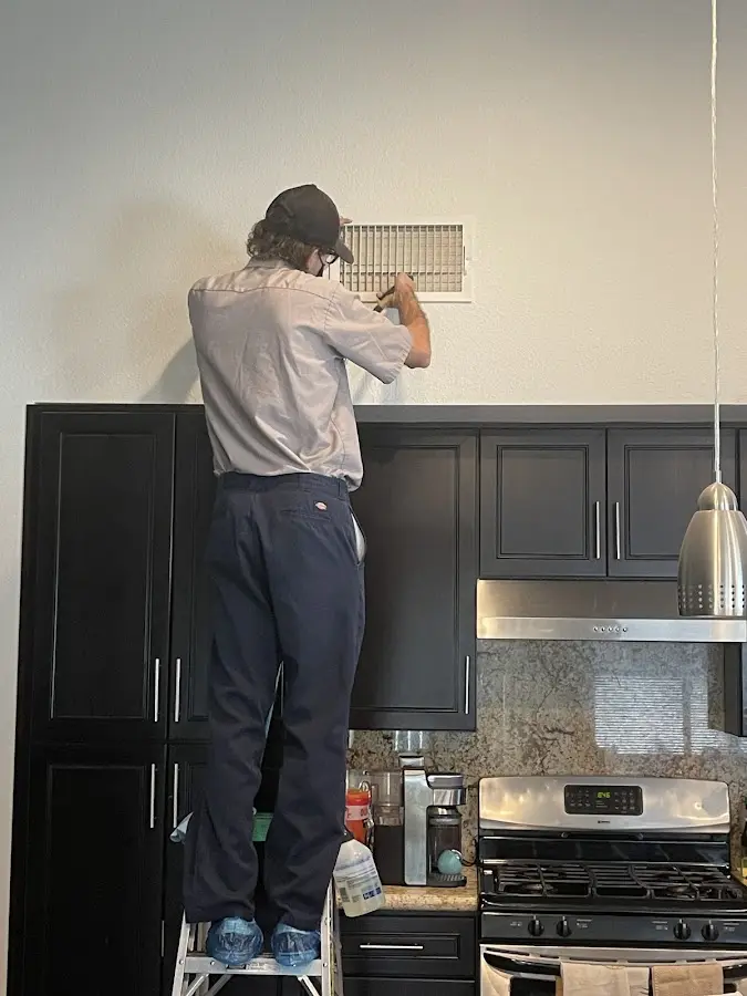 Technician inspecting an air vent during HVAC service in Trenton